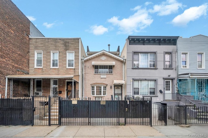View of front facade with a gate, a fenced front yard, and a residential view
