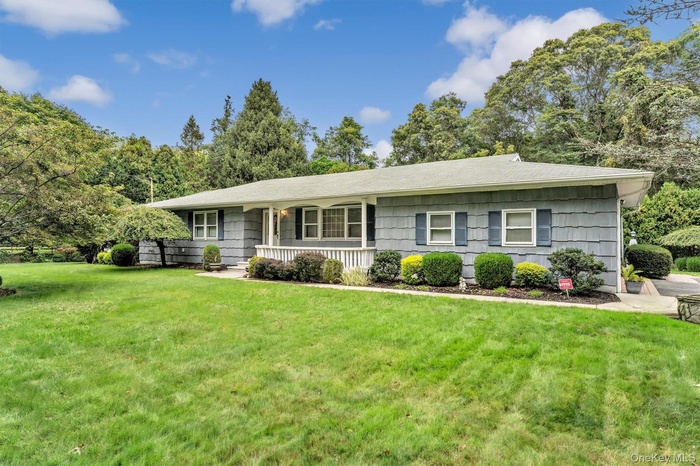 Ranch-style house with a front lawn and a porch