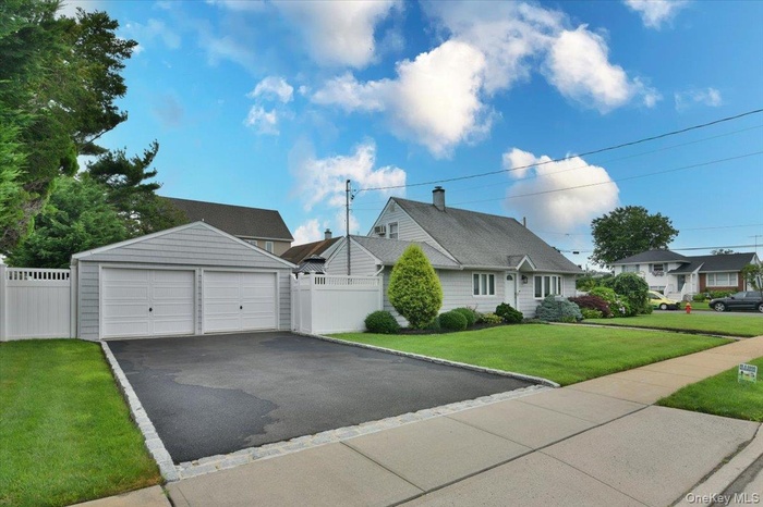 View of front of house featuring a garage, a chimney, and an outdoor structure