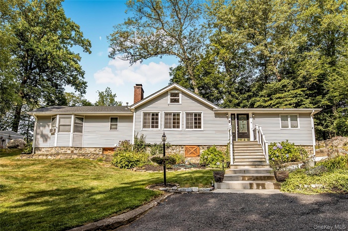 View of front of home featuring a chimney and a front yard