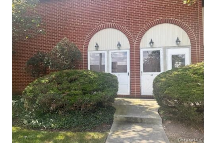Entrance to property featuring brick siding