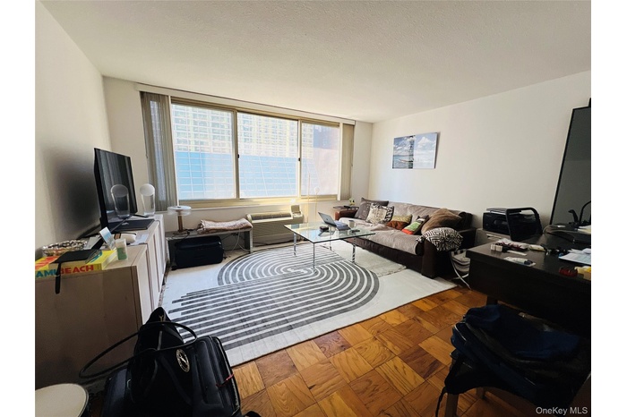 Living room featuring a textured ceiling and a wall unit AC