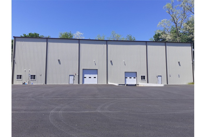 View of building exterior with a garage and a pole building