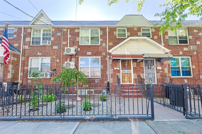 Traditional-style house featuring a fenced front yard, brick siding, and a shingled roof