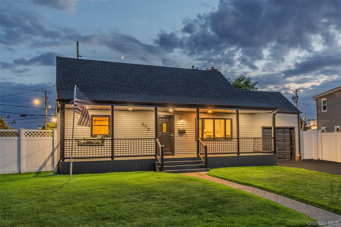 View of front of property featuring roof with shingles, covered porch, and asphalt driveway