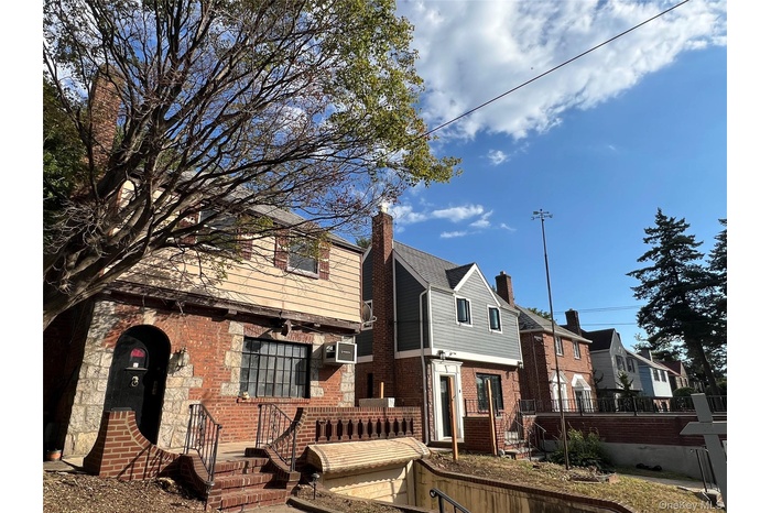 View of front facade with brick siding, a chimney, and a residential view