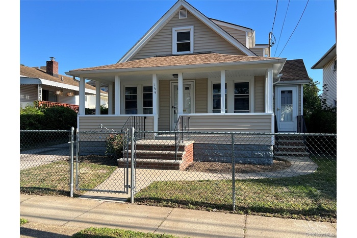 View of front of home featuring a gate, covered porch, a fenced front yard, and roof with shingles