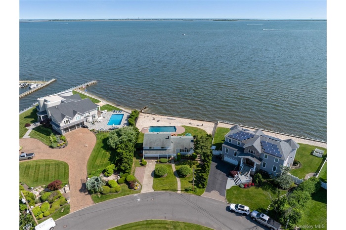 Bird's eye view of a nearby body of water and a pool