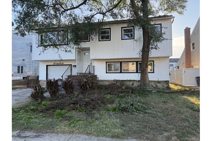 View of front of property featuring a garage and driveway