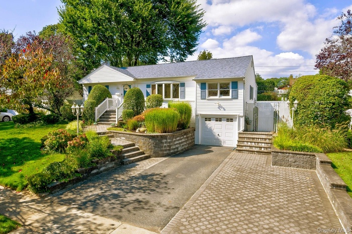 Ranch-style house with stairs, asphalt driveway, and a garage