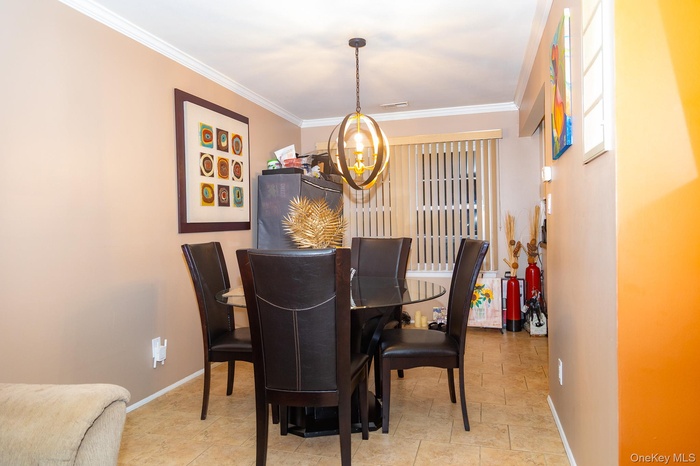 Dining room with ornamental molding and a chandelier