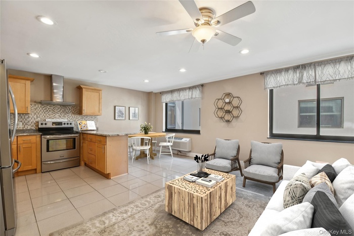 Living area featuring a ceiling fan, recessed lighting, light tile patterned floors, and a wall mounted AC