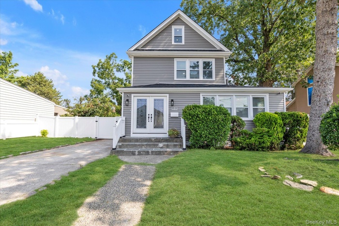 View of front of property featuring a front yard and french doors