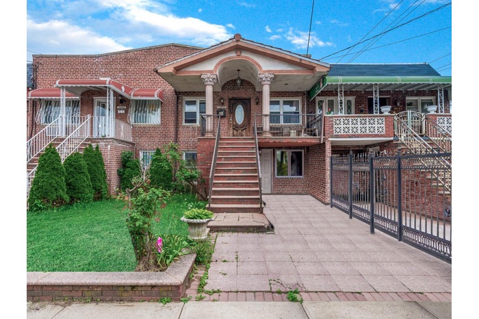View of property with stairs and brick siding