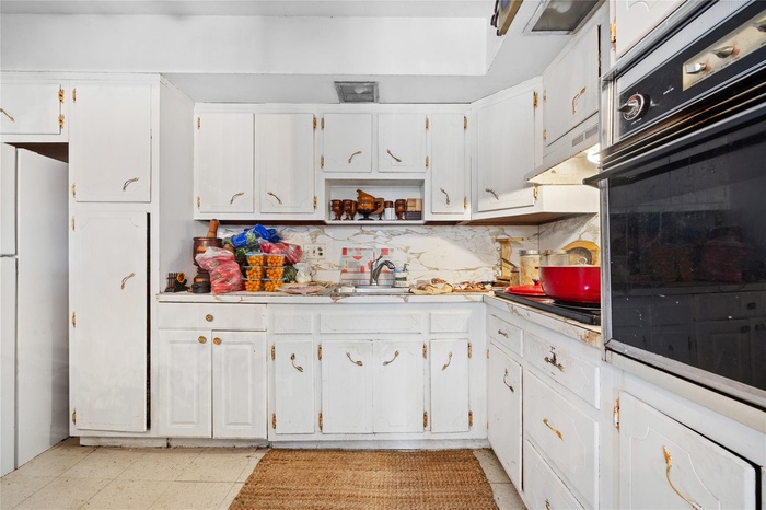 Kitchen 2nd Floor featuring light countertops, freestanding refrigerator, white cabinetry, under cabinet range hood, and oven