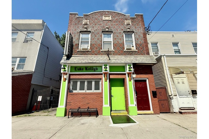 View of front of house featuring brick siding and cooling unit