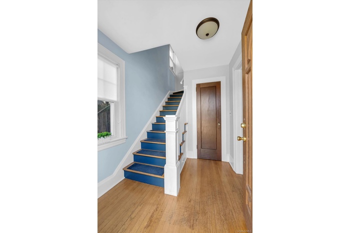 Foyer with light wood-type flooring and stairs