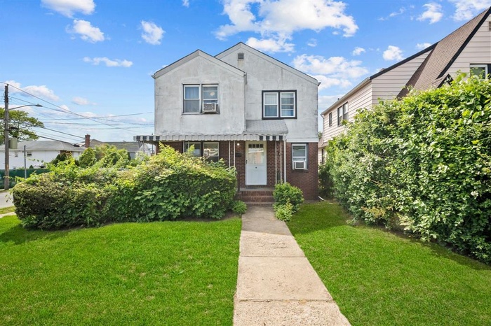 View of front of property with a front lawn and brick siding
