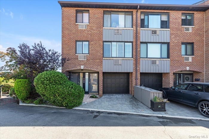 View of property featuring an attached garage and driveway