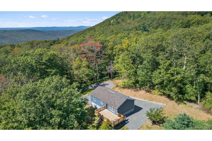 View from above of property featuring a heavily wooded area and mountains