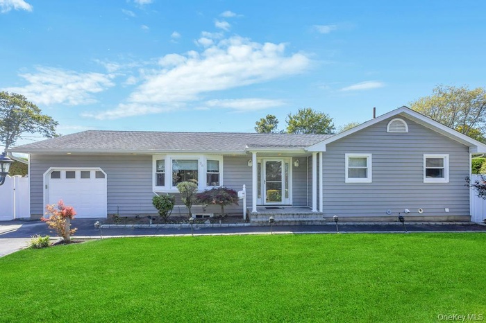 Ranch-style house featuring roof with shingles, a garage, and driveway