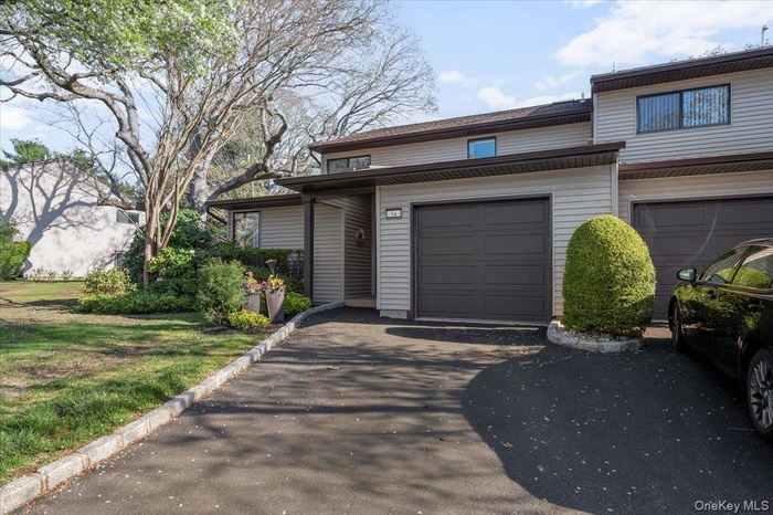 View of front facade featuring an attached garage and driveway