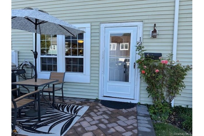 View of exterior entry featuring a patio and outdoor dining space