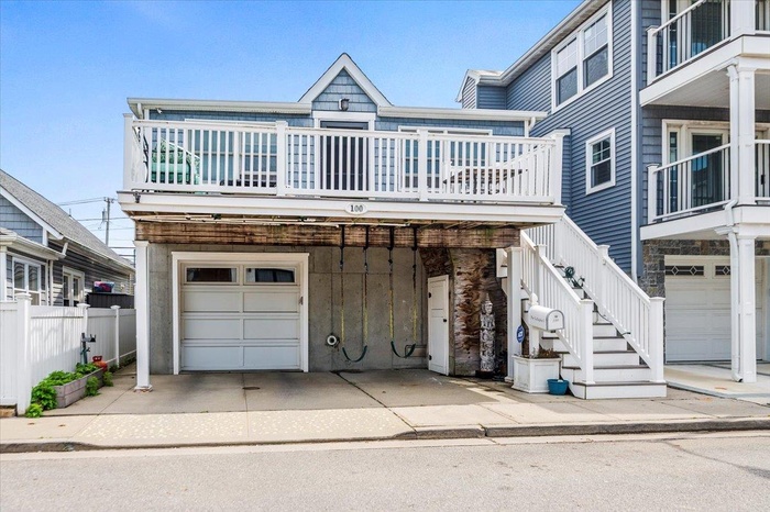 View of front of property featuring an attached garage and fence