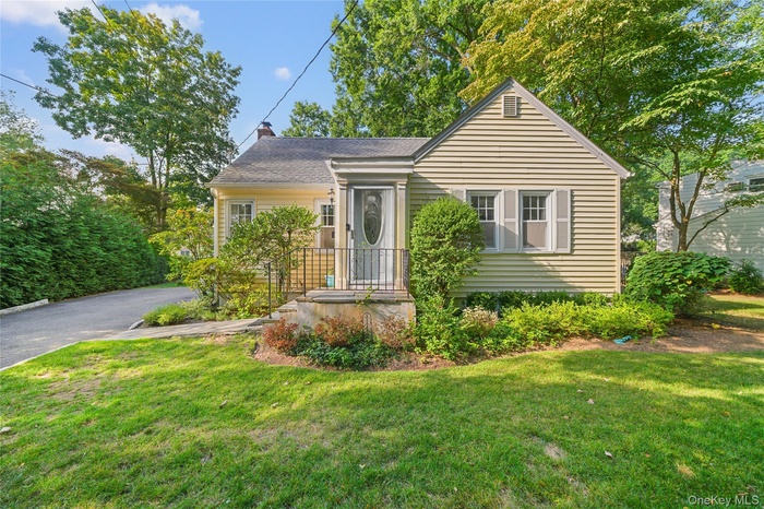 Bungalow with a front lawn, a chimney, and a shingled roof