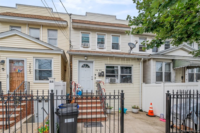 Traditional-style home featuring a fenced front yard, a gate, cooling unit, and entry steps