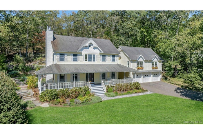 View of front of property with stairs, a porch, a chimney, driveway, and a front yard