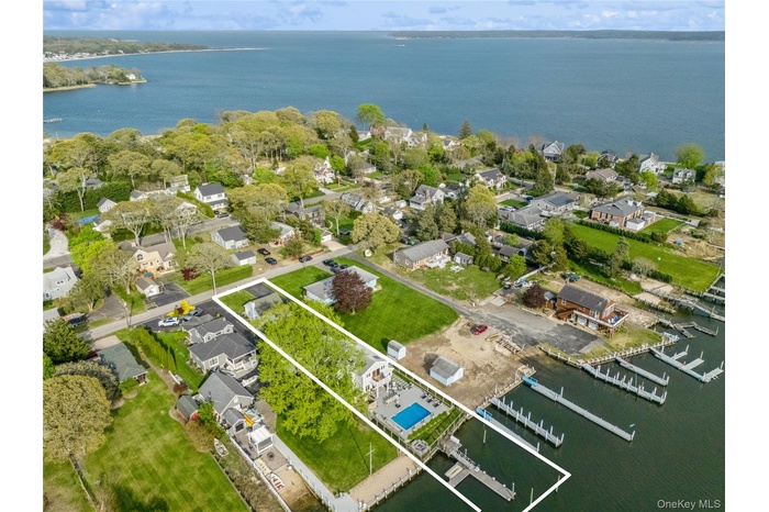 View of property location featuring a nearby body of water, nearby suburban area, and property parcel outlined