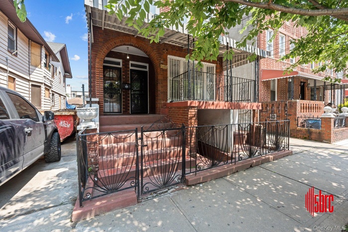 View of front facade featuring brick siding, a fenced front yard, and a gate