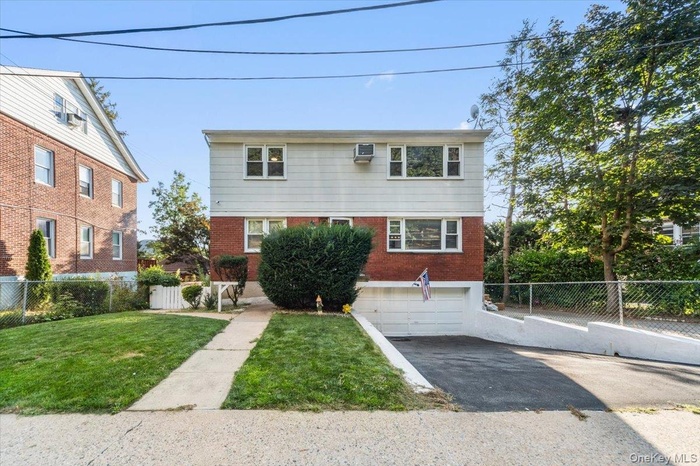 View of front of home featuring brick siding, asphalt driveway, and an attached garage