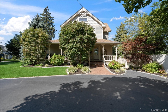 Victorian-style house with a porch and roof with shingles