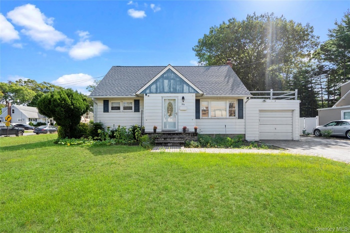 Bungalow with roof with shingles, driveway, a front lawn, a garage, and a chimney