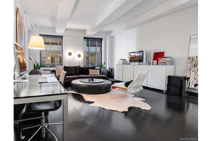 Living room with beamed ceiling and wood finished floors