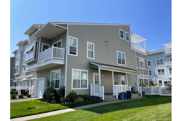 Rear view of house featuring an attached garage and a balcony