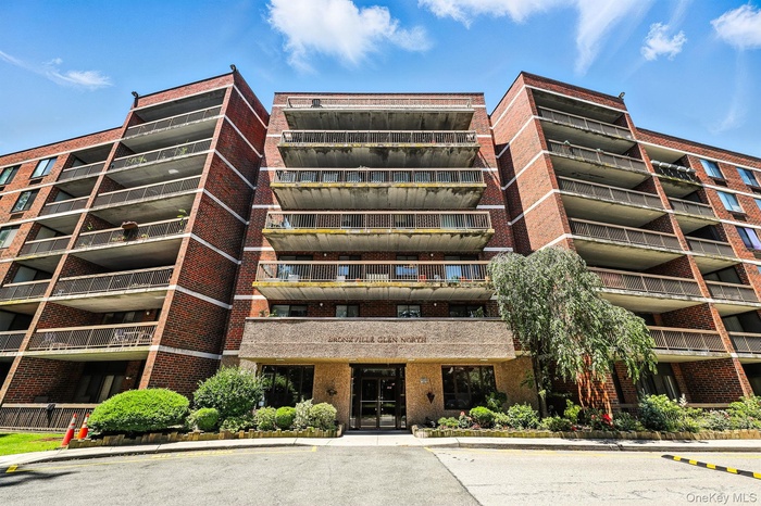 View of apartment building / complex with uncovered parking