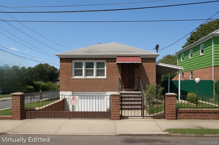 View of front of home featuring a gate, a fenced front yard, brick siding, and a shingled roof