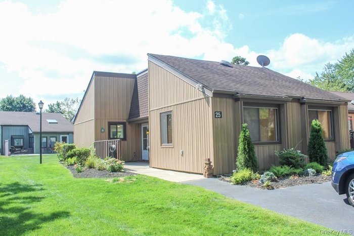 View of front facade with roof with shingles and a front lawn