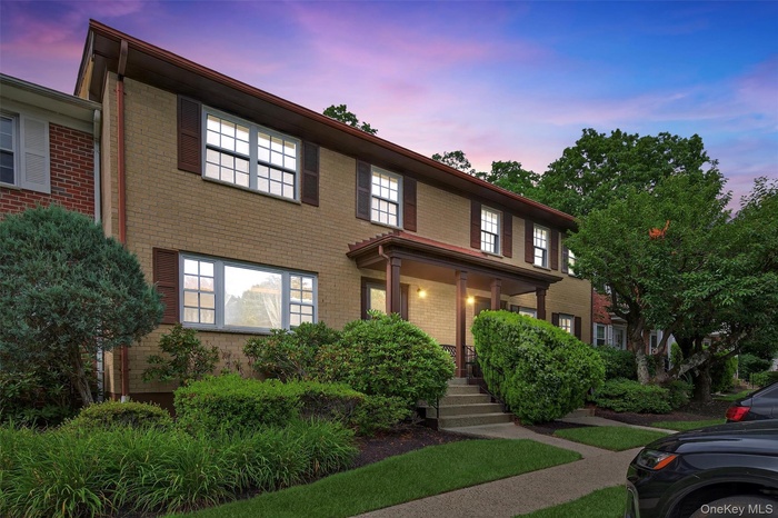View of front of home with brick siding and covered porch