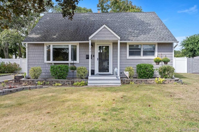 View of front of property with a chimney and roof with shingles