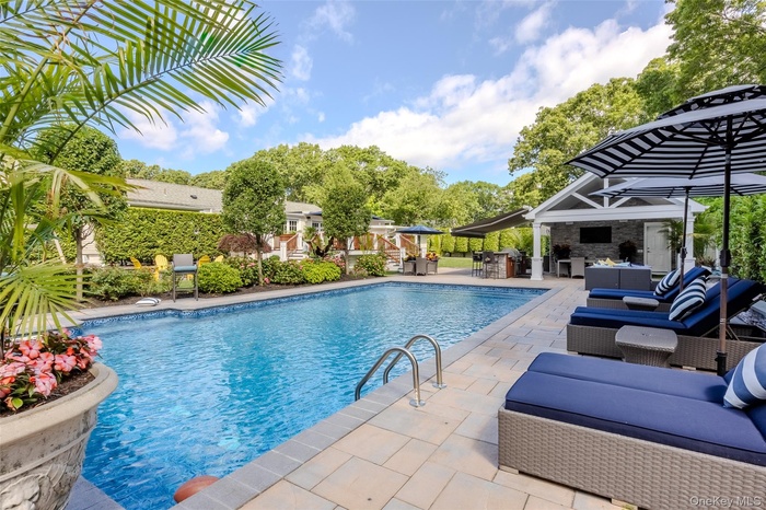 Swimming pool with an outdoor hangout area, a patio area, and a storage structure