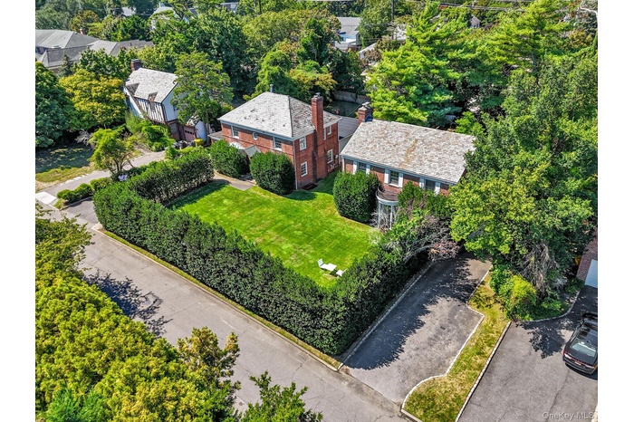 Aerial view of property and surrounding area with a tree filled landscape