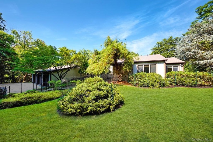 View of grassy yard featuring a sunroom