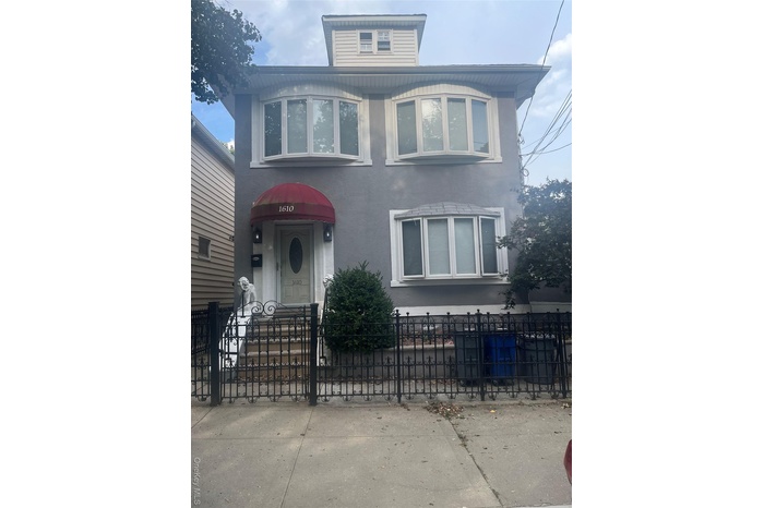 View of front facade featuring stucco siding and a fenced front yard