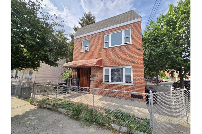 Traditional-style home with brick siding and a fenced front yard