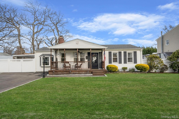 View of front of home featuring a porch, a chimney, and roof with shingles