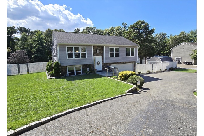 High Ranch home with oversized driveway for extra parking and a 2 car attached garage